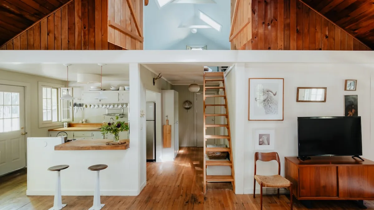Échelle de meunière en bois desservant une mezzanine dans un petit logement